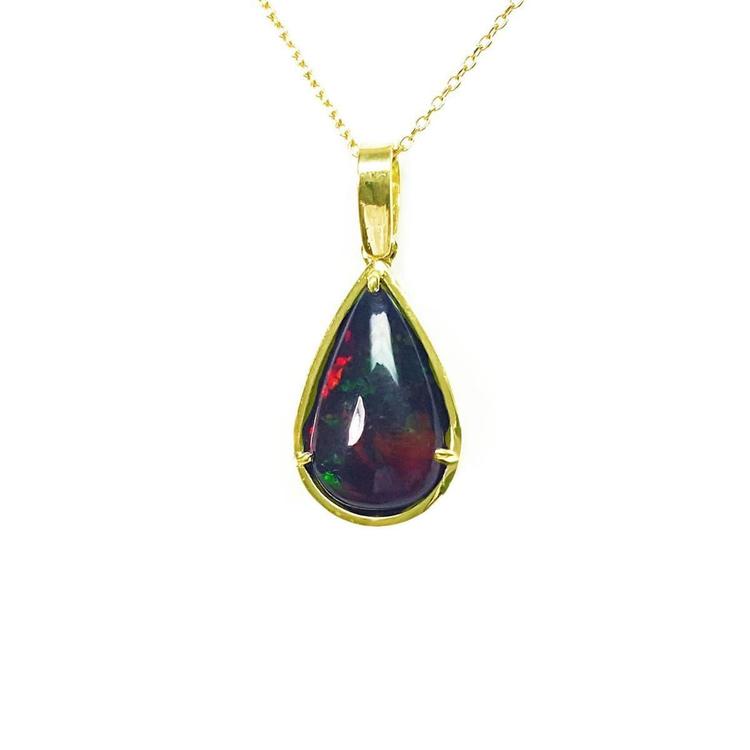 Pear-shaped Welo black opal pendant with red-orange fire and bluish-green flashes, set in 14K yellow gold.