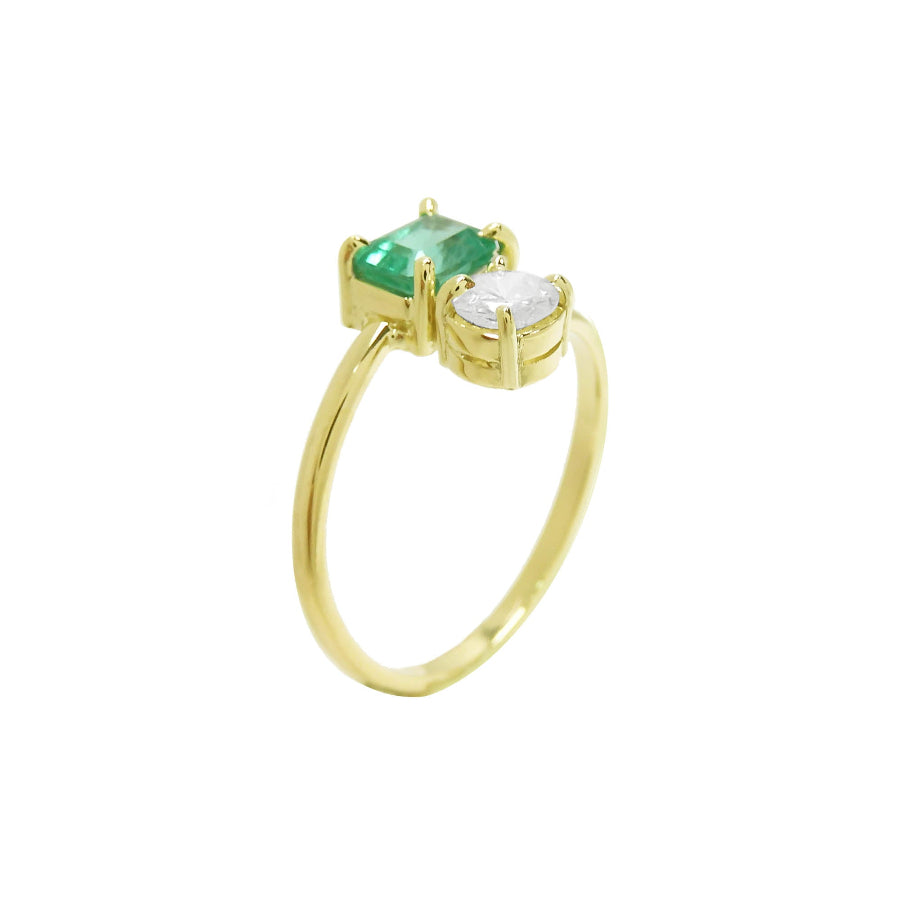 A yellow gold ring featuring a rectangular emerald-cut gemstone and a round clear stone, set on a polished gold band.