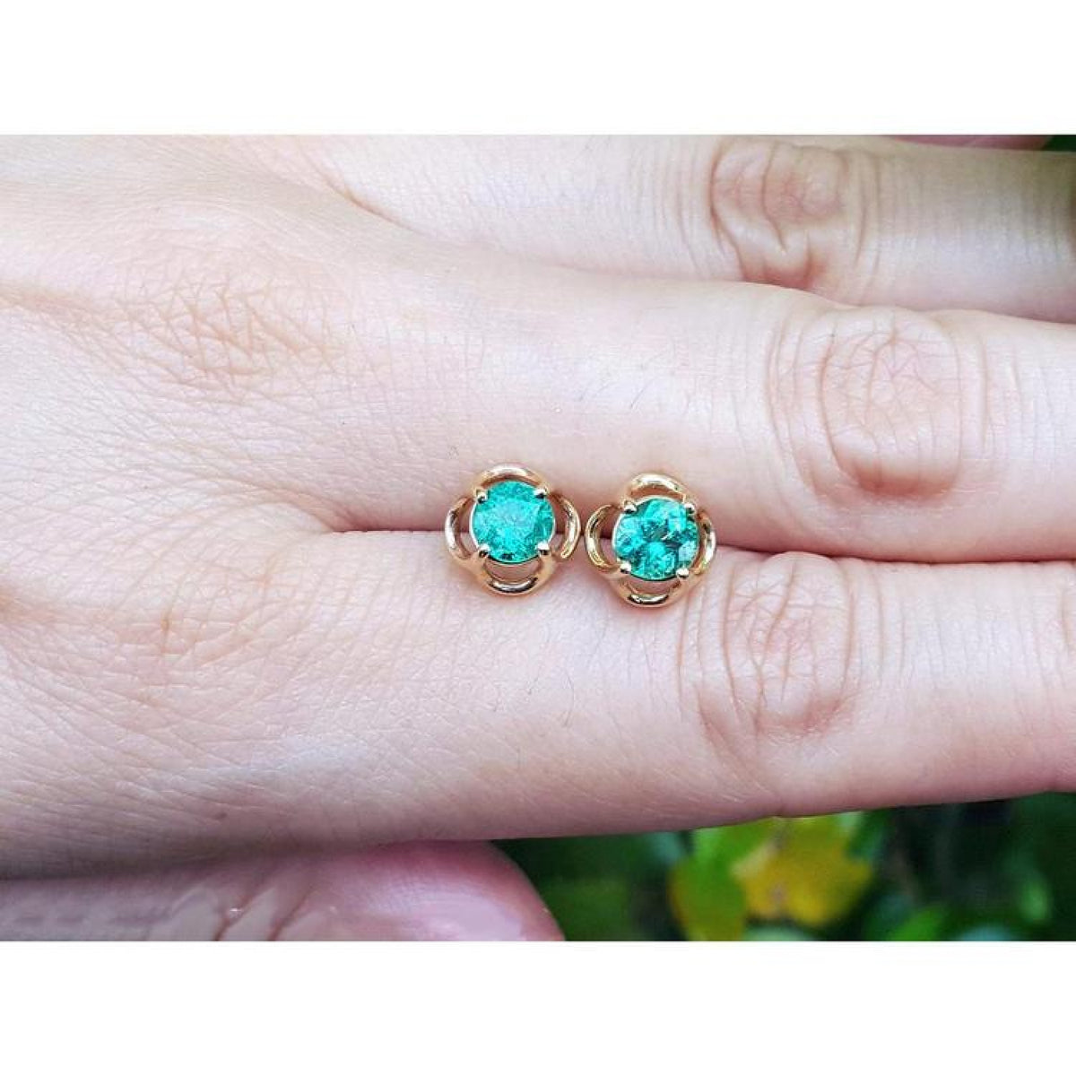 Colombian emerald tulip stud earrings in 14K yellow gold with round-cut green emeralds.