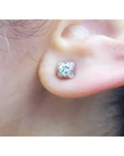 A woman's ear wearing a 14k white gold diamond stud earring, tulip style.
