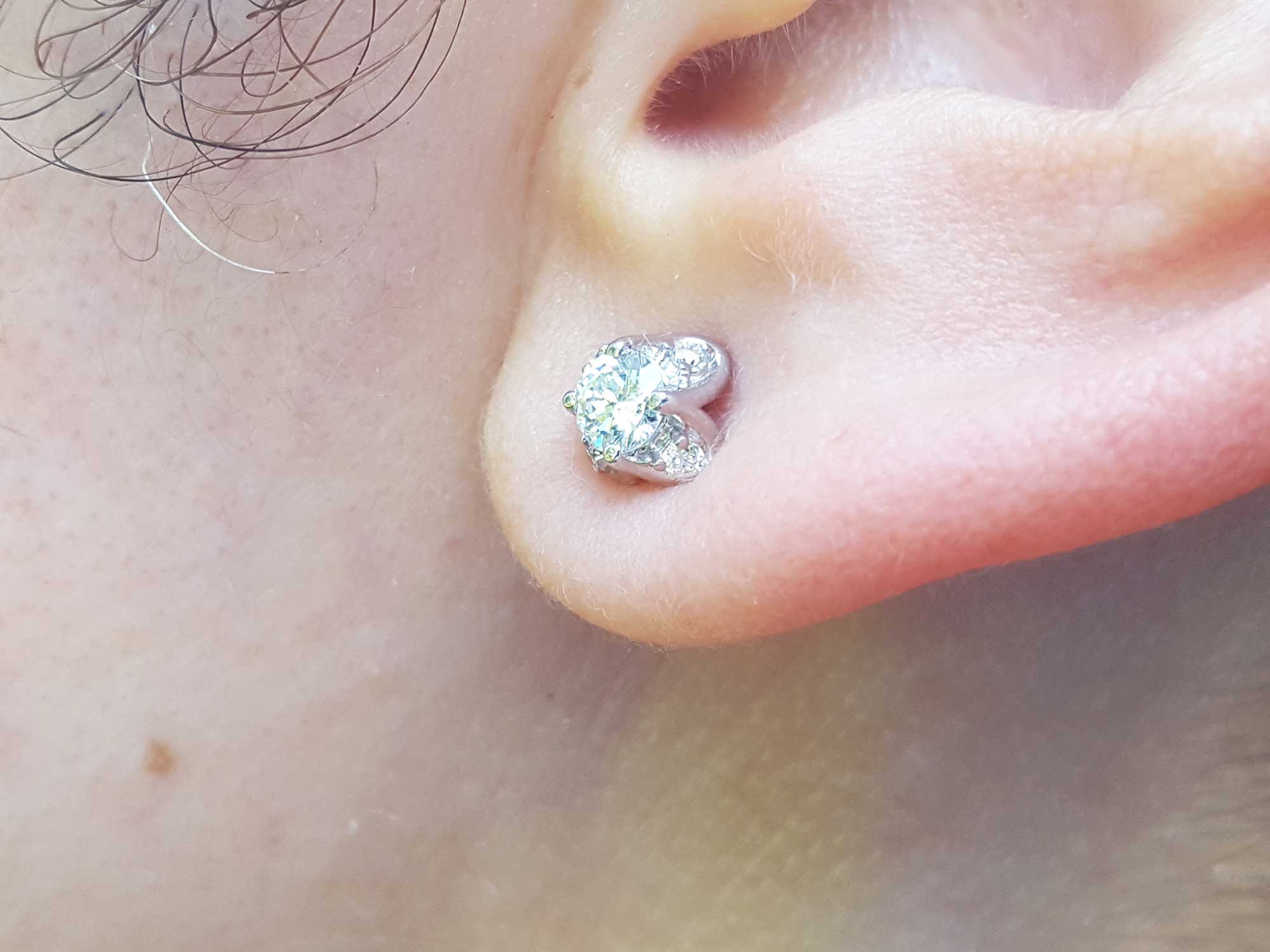 Close-up of an ear wearing a natural diamond tulip stud earrings in white gold.