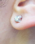 Close-up of an ear wearing a natural diamond tulip stud earrings in white gold.