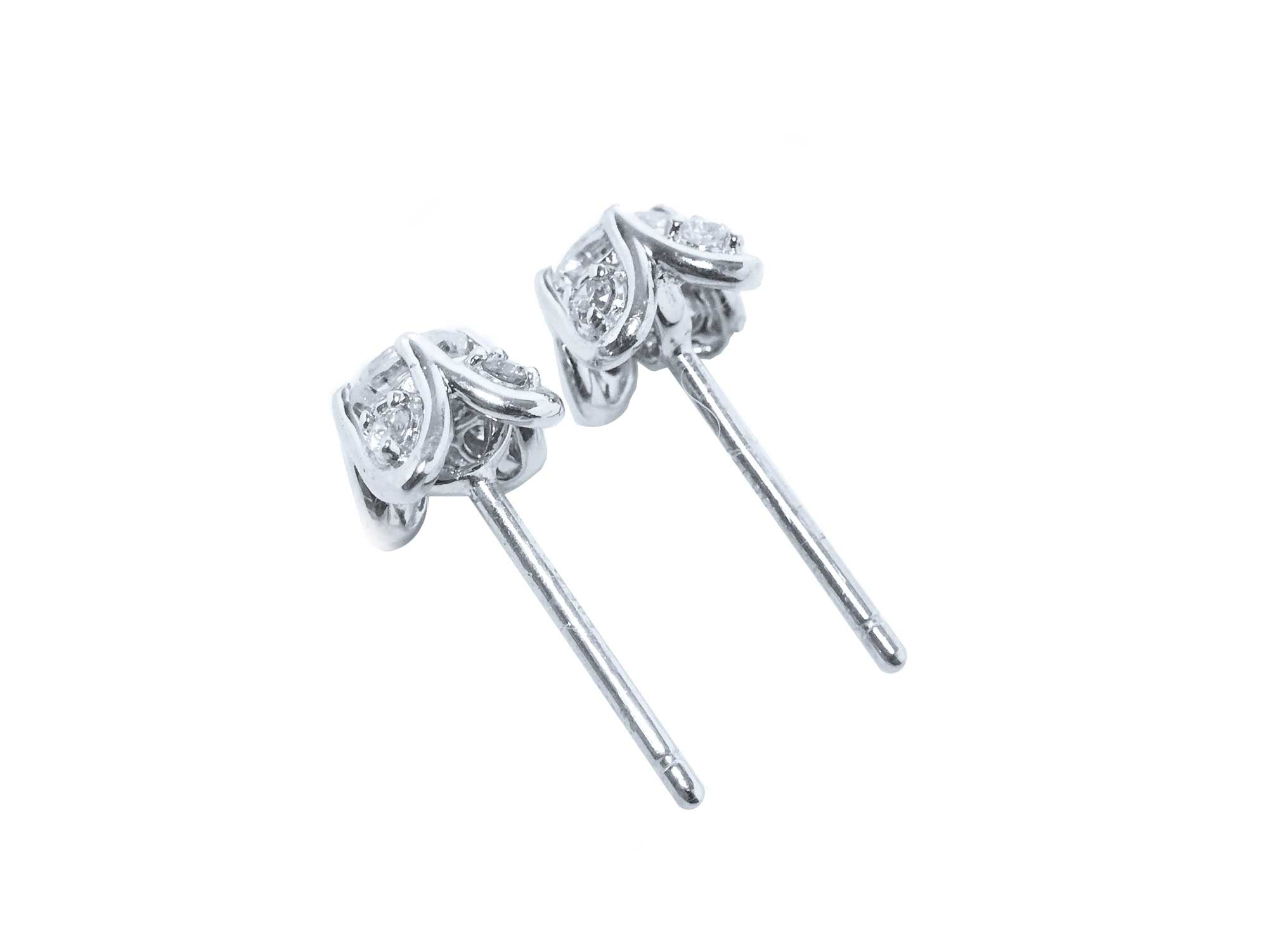A pait of natural diamond tulip stud earrings in white gold, underside profile view.