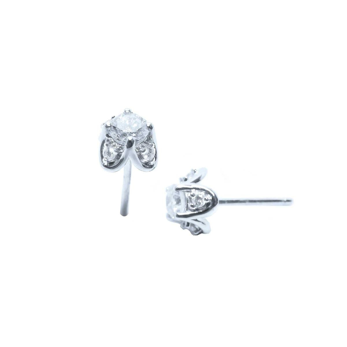 Two positions displaying a pair of white gold diamond stud earrings, tulip style, side profile view.