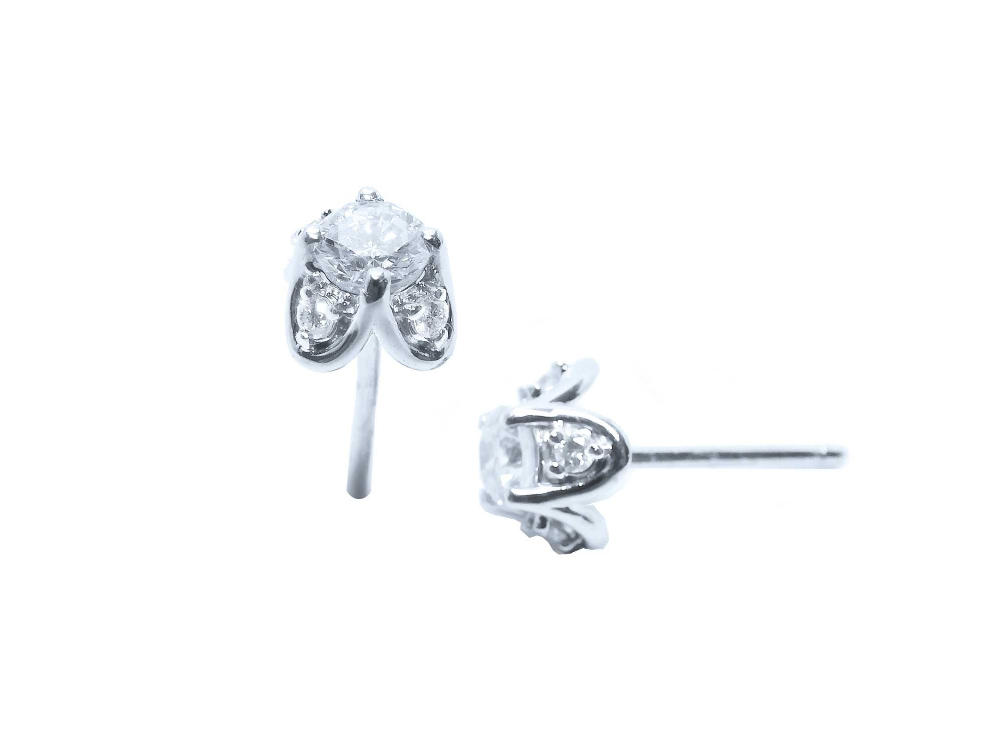 Two positions displaying a pair of white gold diamond stud earrings, tulip style, side profile view.