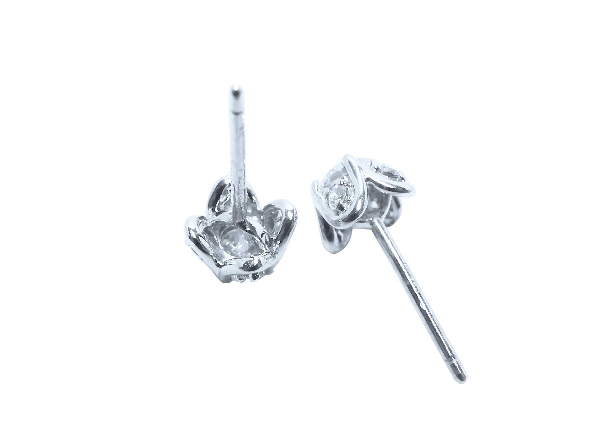 On upside down position a pair of natural diamond tulip stud earrings in white gold, underside profile view.