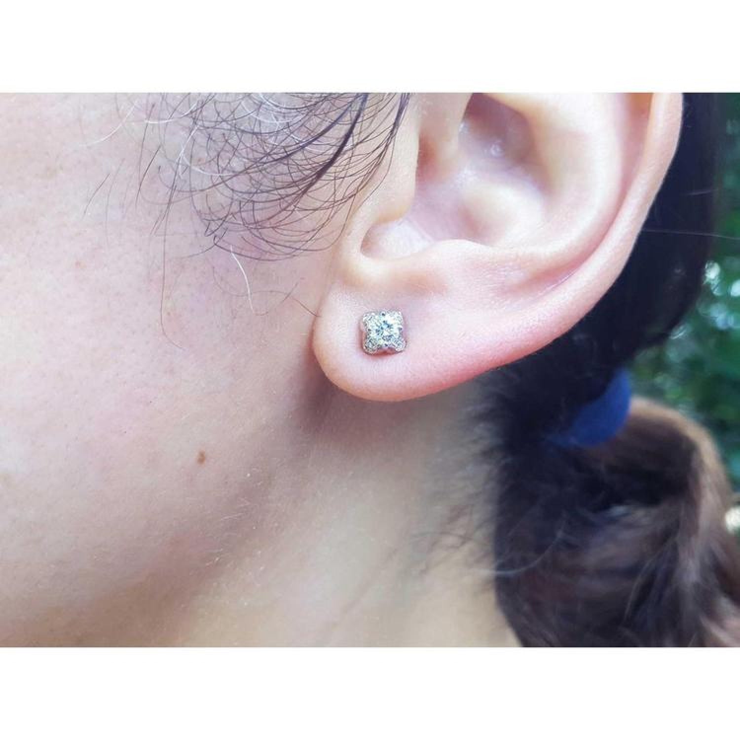 0.59 ct. round diamond tulip stud earrings in 14K white gold on an ear.
