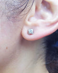 A woman's ear wearing a natural diamond tulip stud earring in white gold.
