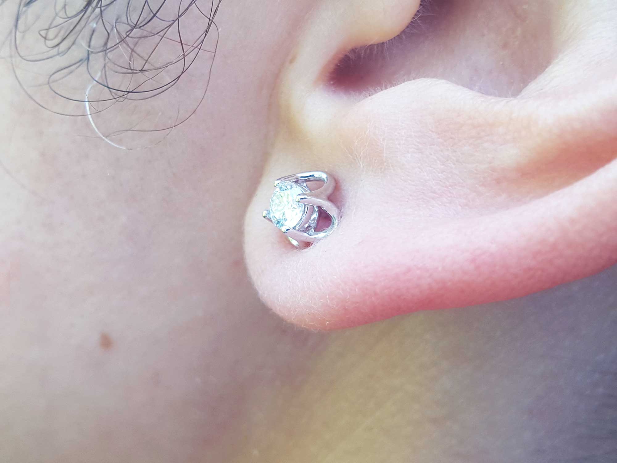 Close-up of an earlobe dressing a natural diamond tulip stud earring.