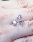 Displayed on a person's hand a pair of natural diamond tulip stud earrings, push backs.