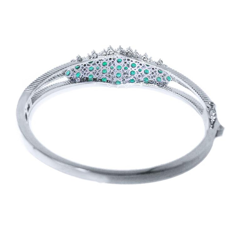 14k white gold bangle bracelet with round Colombian emeralds and diamonds.