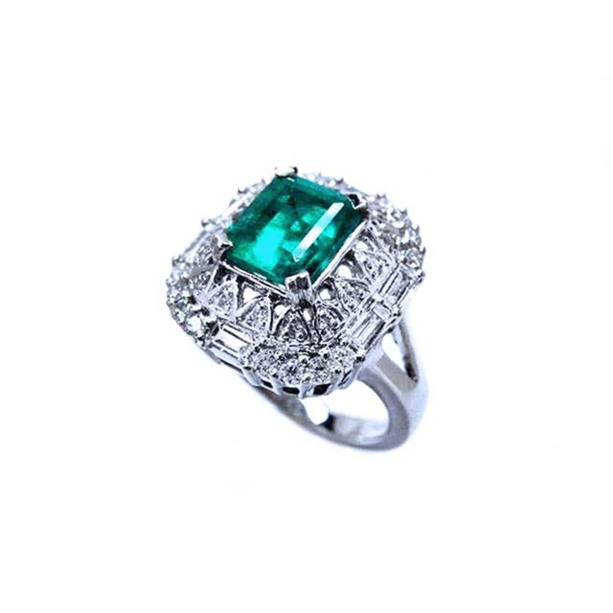 A unique vintage emerald ring with baguette and round diamonds, showing the topside and side profile.