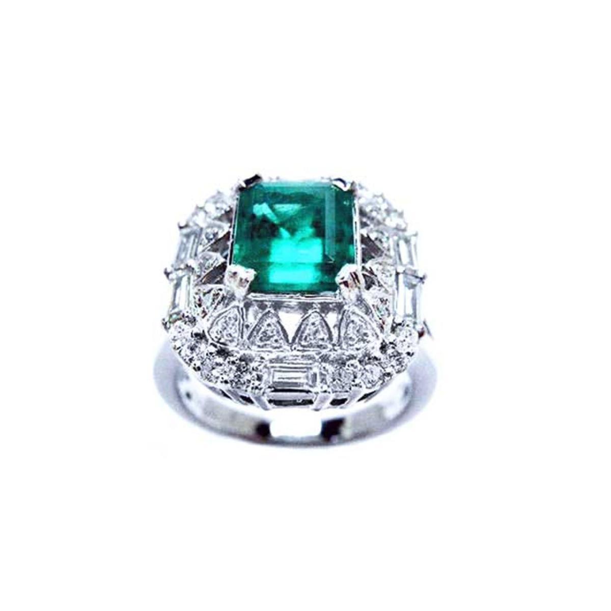 This emerald and baguette diamonds vintage ring in white gold displays its top view.