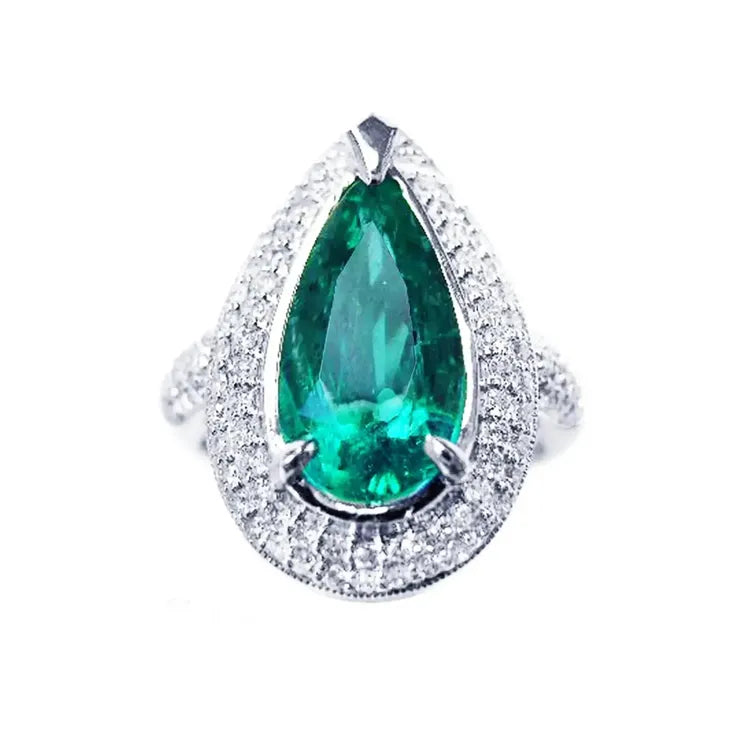 Esmeralda corte pera o lagrima rodeada de diamantes naturales en anillo de oro blanco para mujer.