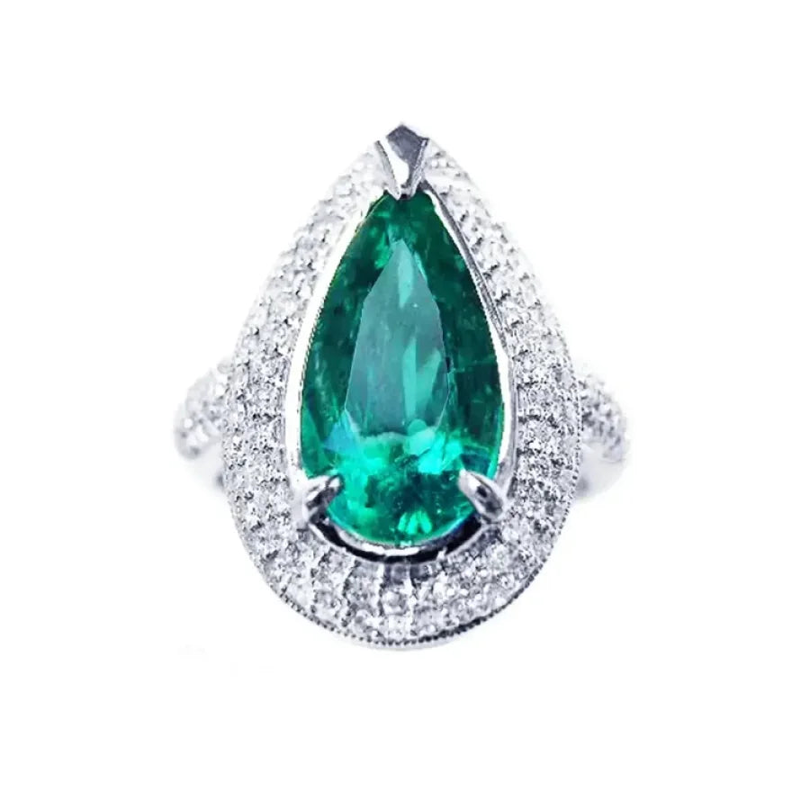 Esmeralda corte pera o lagrima rodeada de diamantes naturales en anillo de oro blanco para mujer.