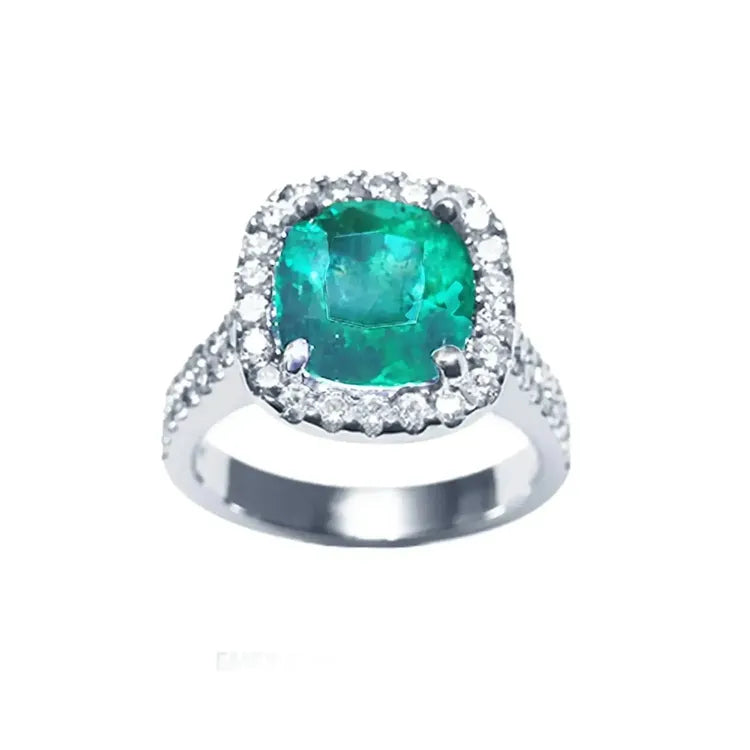 Anillo de oro blanco para mujer con genuina esmeralda colombiana corte cojín rodeado de diamantes naturales.