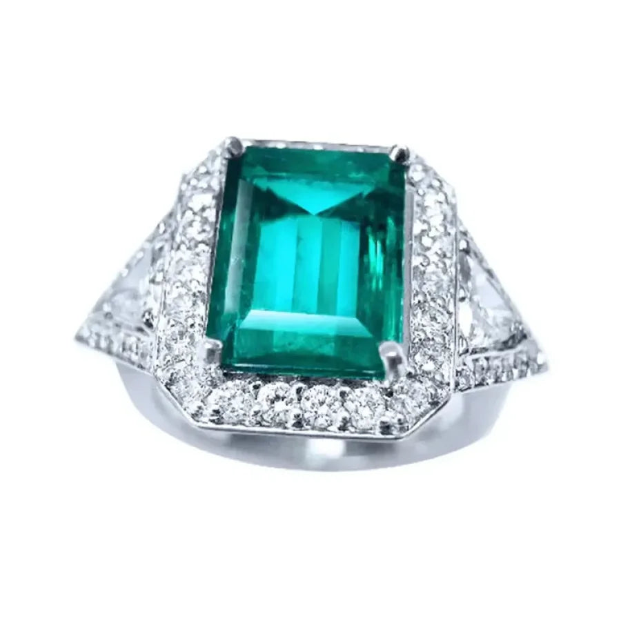 Anillo de oro blanco 18K con esmeralda colombiana rectangular de 3.98 ct. rodeada de diamantes.