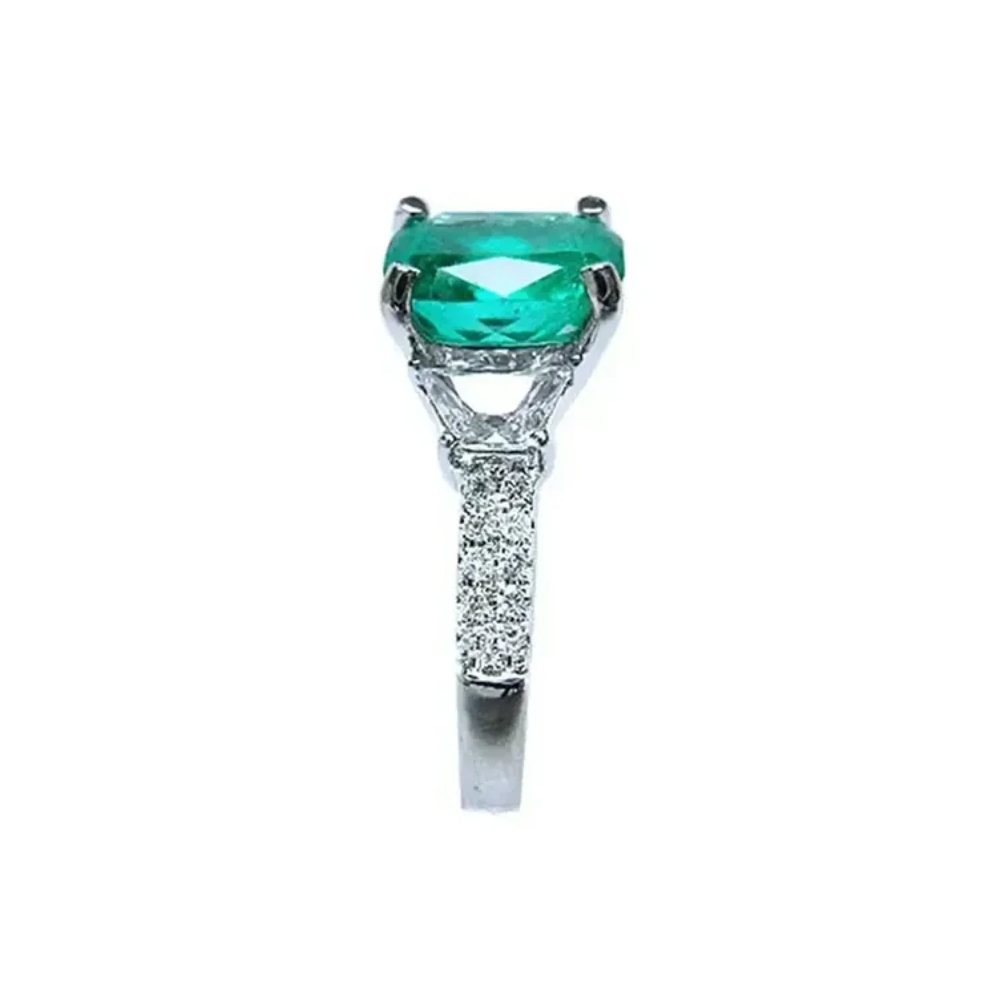 Anillo de compromiso de oro blanco 18k con esmeralda colombiana ovalada y diamantes trapezoide.