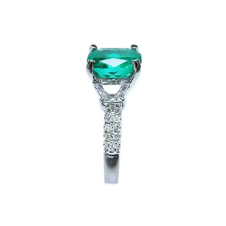 Vista lateral de anillo de 18k con esmeralda para damas hecho en oro blanco.