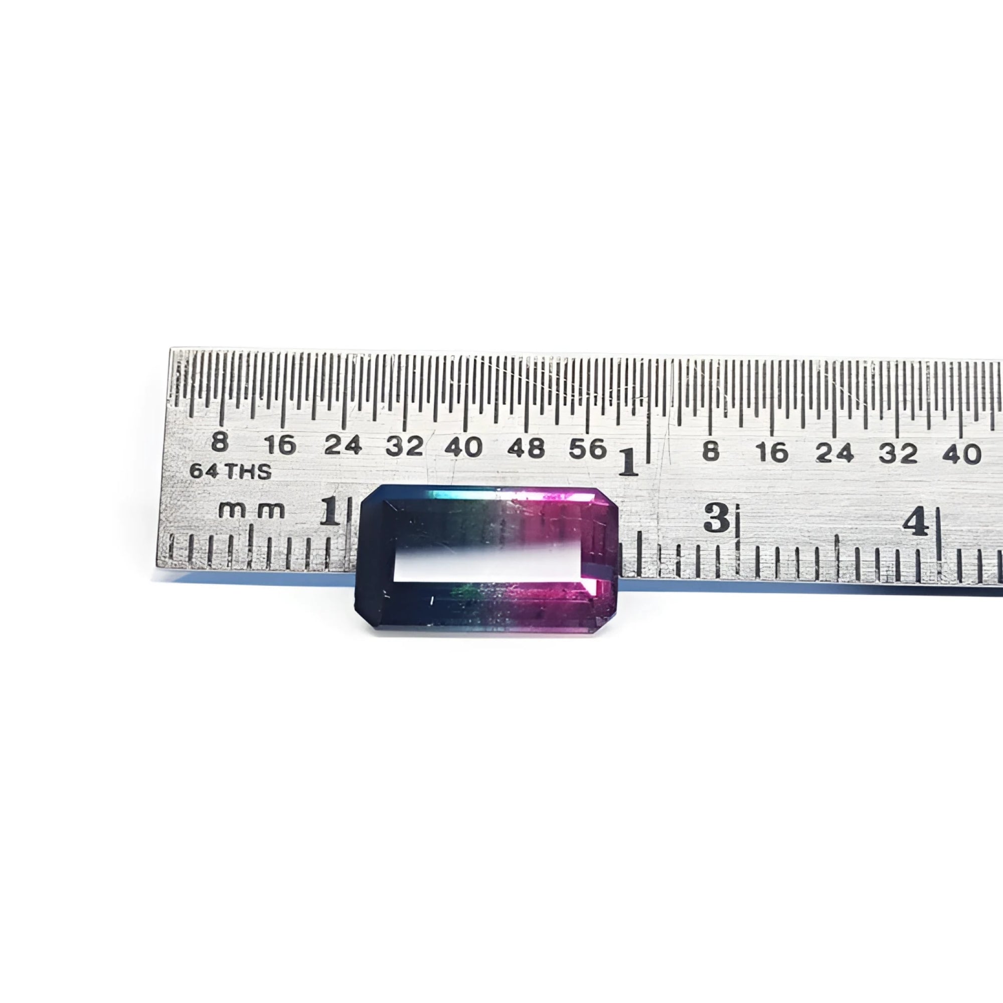 Rectangular emerald cut watermelon tourmaline with vibrant red-orange and deep blue-green colors, next to a ruler.