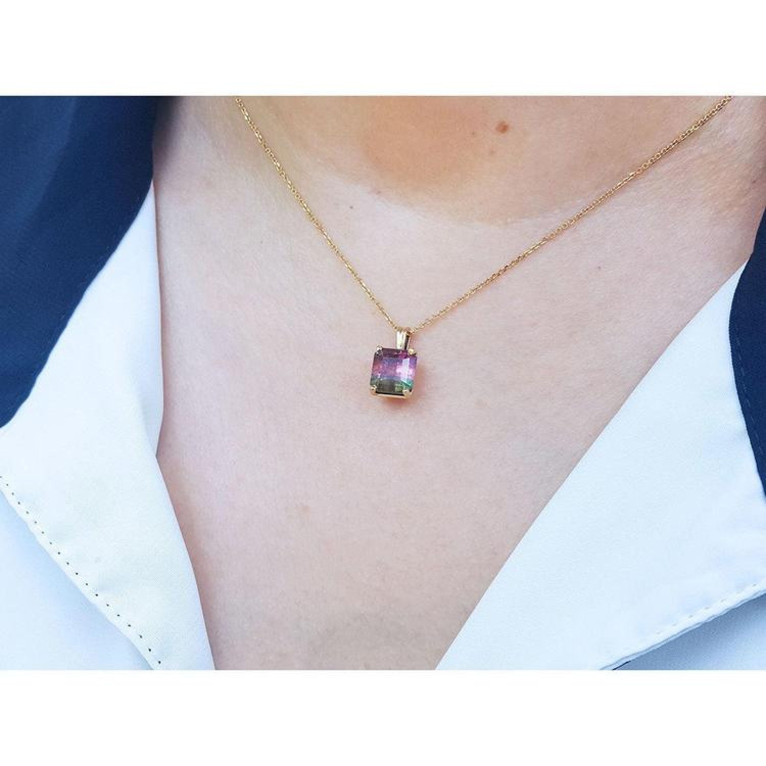 Brazilian bicolor tourmaline watermelon solitaire pendant in 14K yellow gold on a model.