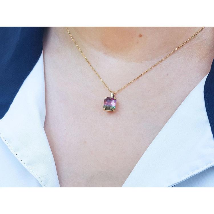 Brazilian bicolor tourmaline watermelon solitaire pendant in 14K yellow gold on a model.