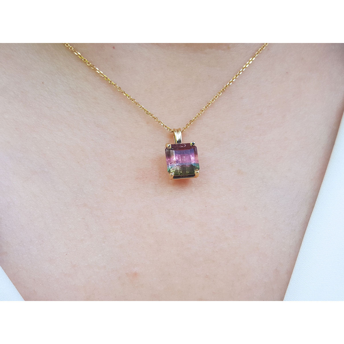 Necklace with a colorful tourmaline pendant on a person&#39;s neck.