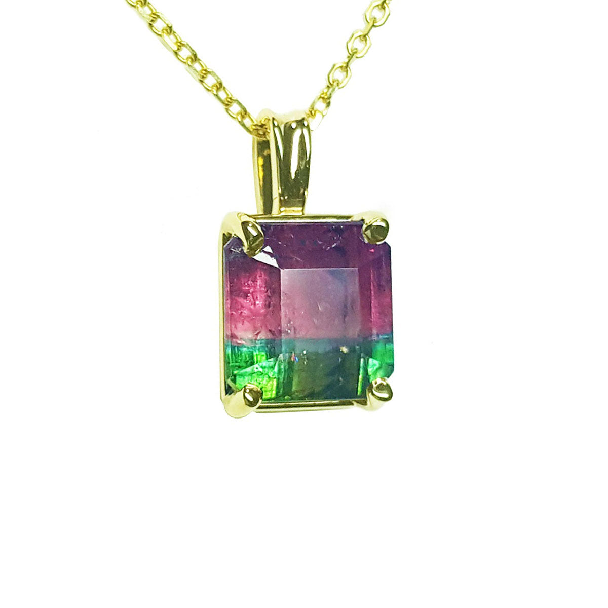 Multicolored tourmaline gemstone pendant on a gold chain against a white background.