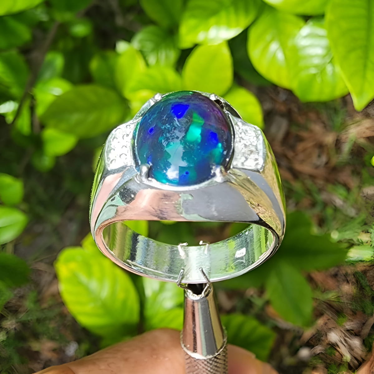 Men's sterling silver ring with a sparkling blue, red, and green Welo black opal.