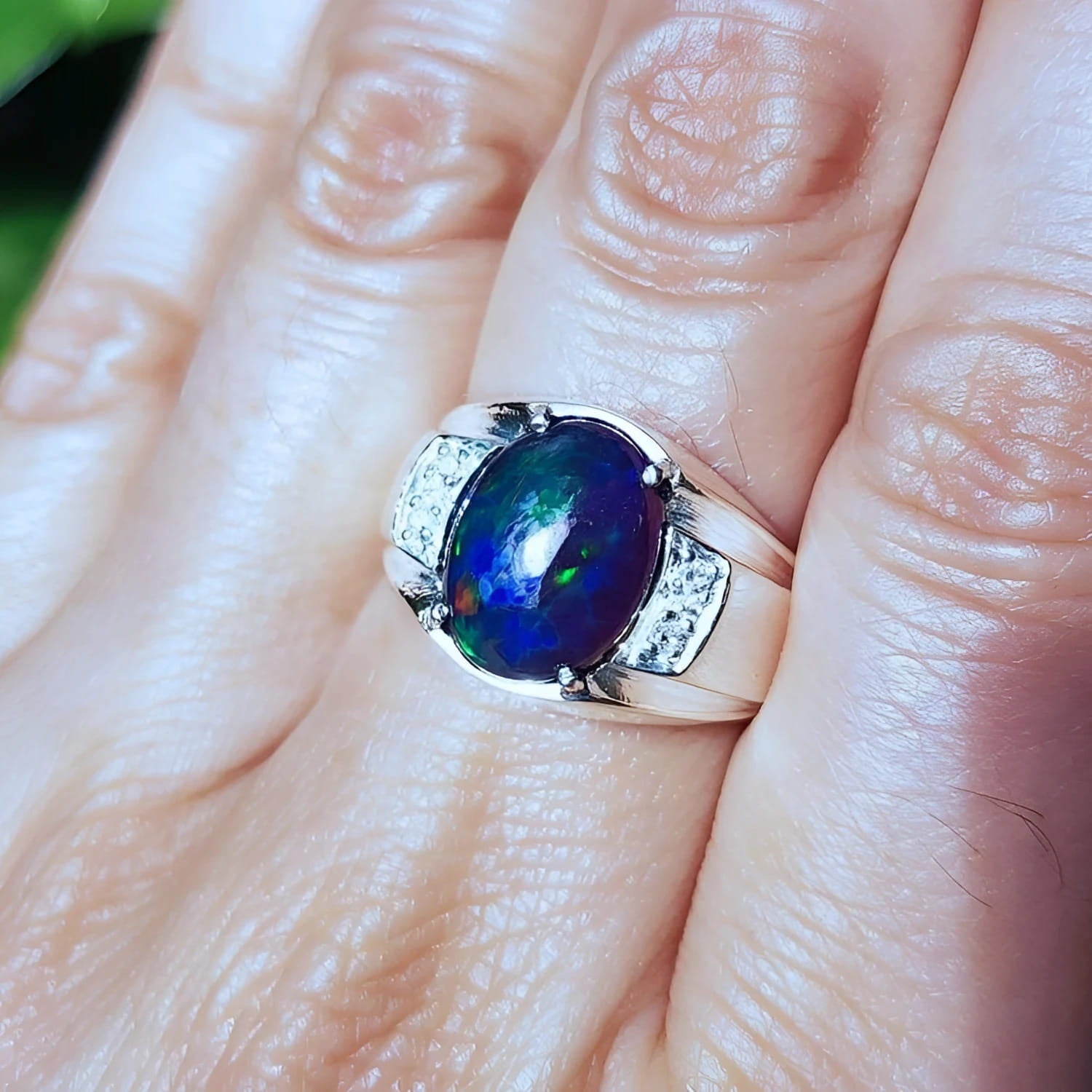 Men's sterling silver ring with a sparkling blue Welo black opal.