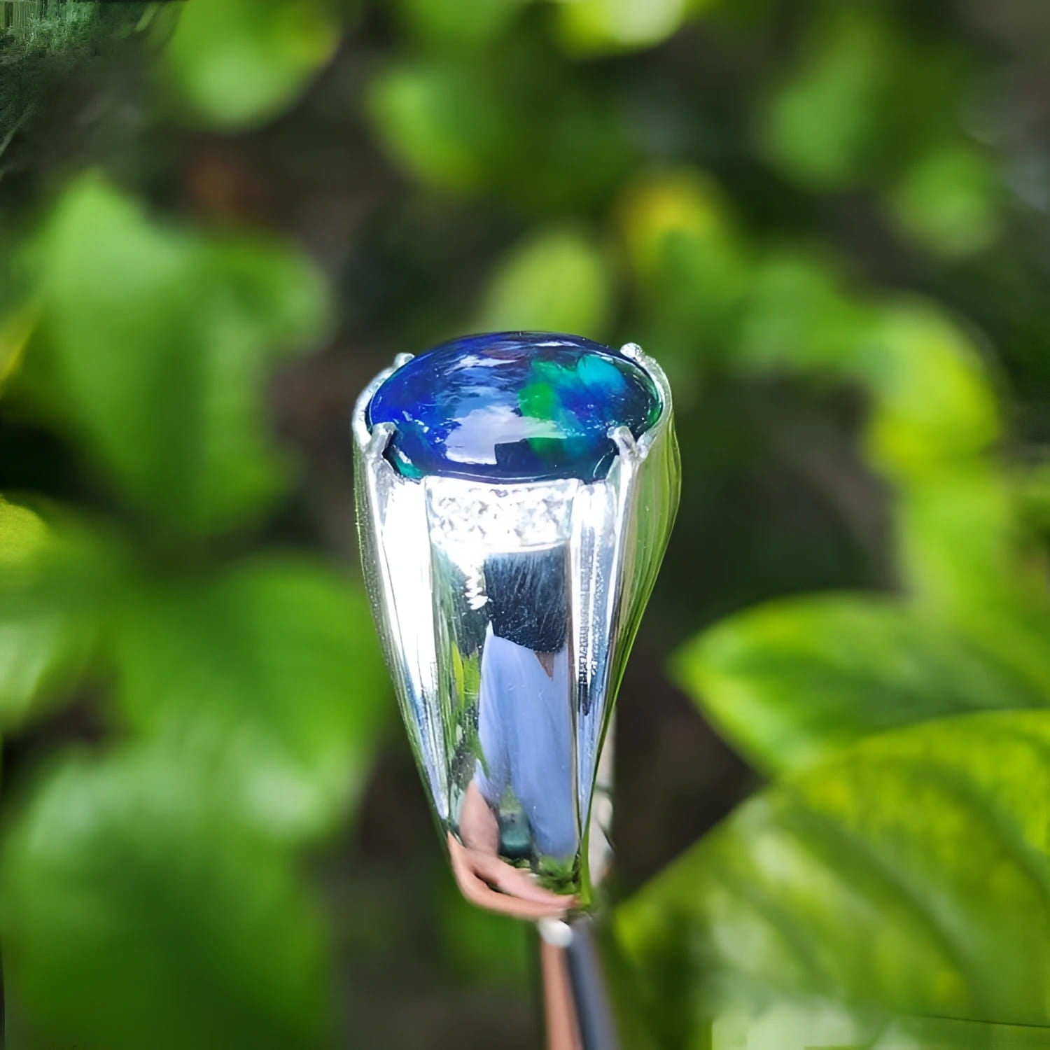 Men's sterling silver ring with a sparkling blue, red, and green Welo black opal.