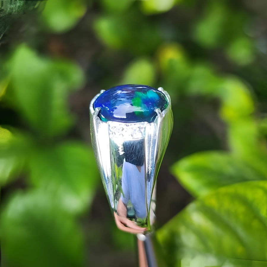 Men's sterling silver ring with a sparkling blue, red, and green Welo black opal.