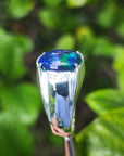 A genuine Ethiopian black opal silver ring for men against a green leafy background