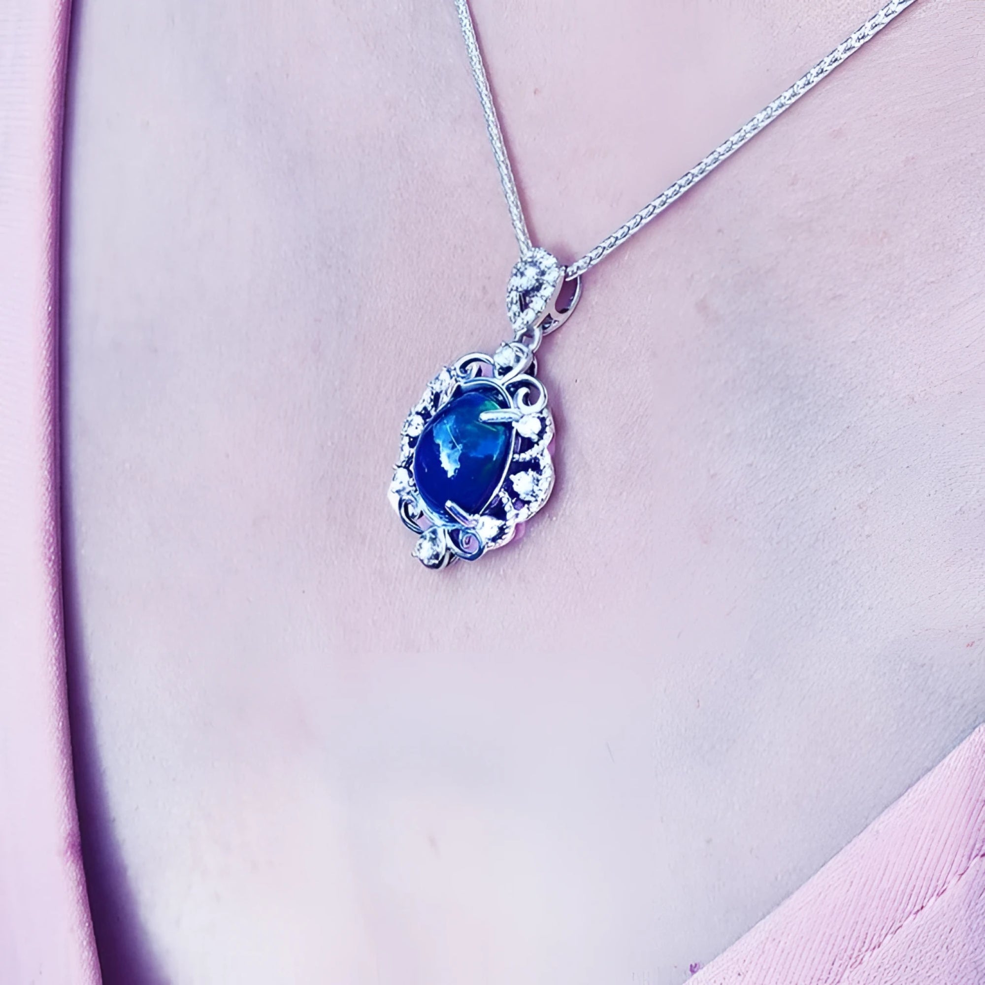 Multicolor Welo Ethiopian black opal pendant in ornate sterling silver with CZ accents on a silver chain.