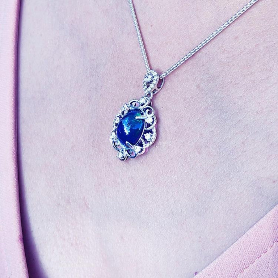 Multicolor Welo Ethiopian black opal pendant in ornate sterling silver with CZ accents on a silver chain.