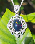 Silver pendant with a colorful Ethiopian black opal on a green leaf