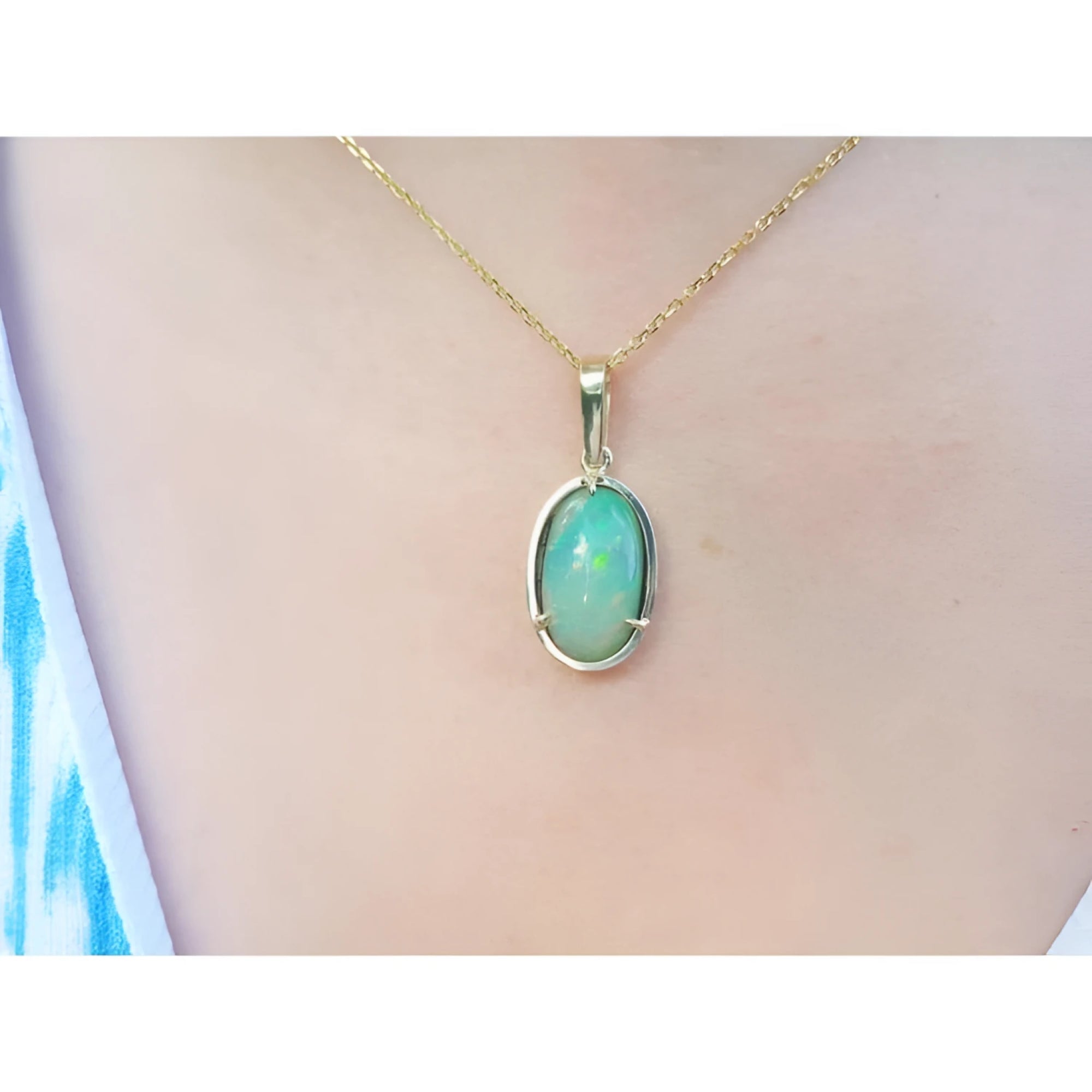 2.86 ct. oval Ethiopian opal pendant with bluish-green hues, prong set in 14K yellow gold on a chain.