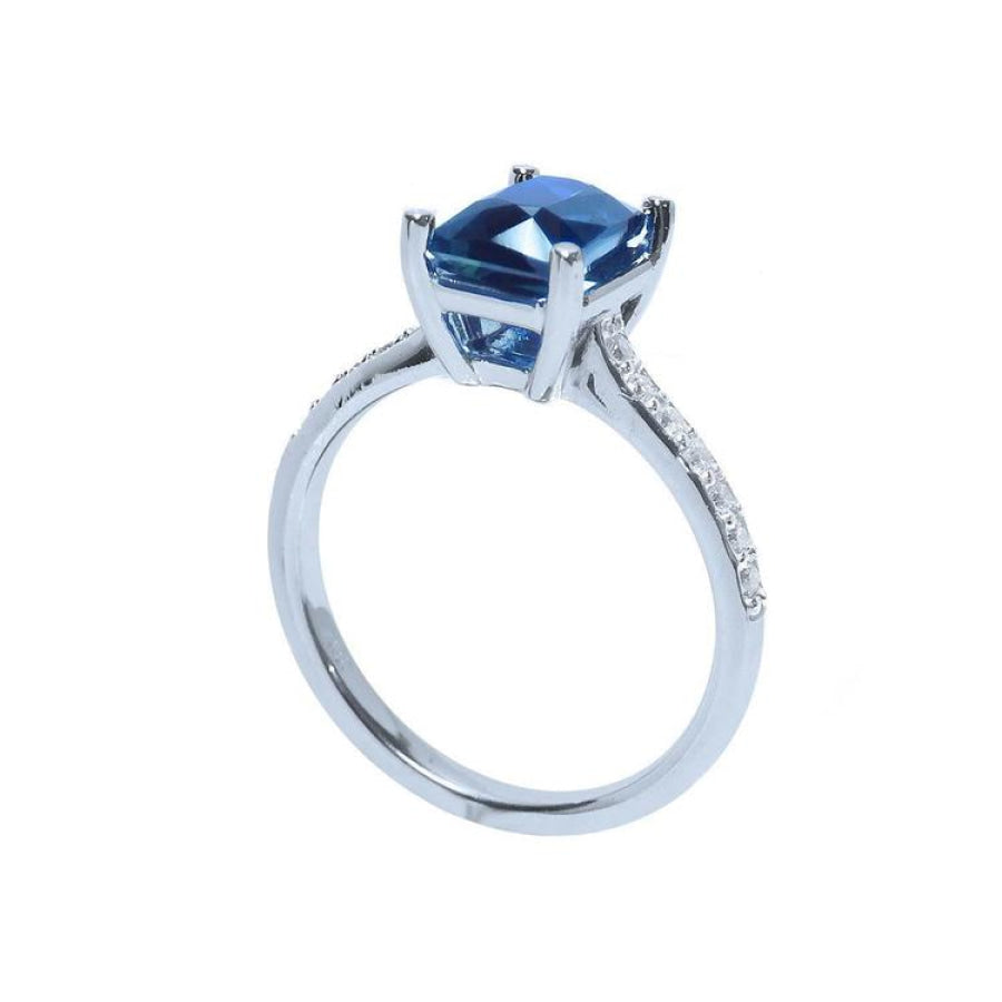 18K white gold ring with a radiant-cut blue sapphire and diamond accents.
