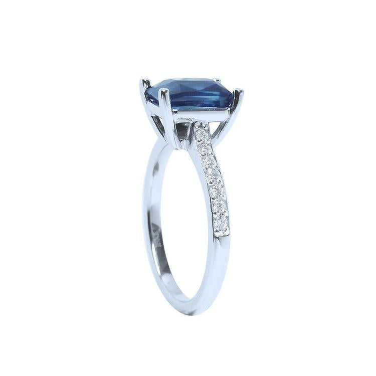 18K white gold ring with a radiant-cut deep blue sapphire and diamond accents.