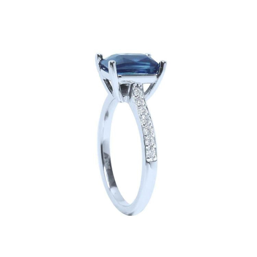 18K white gold ring with a radiant-cut deep blue sapphire and diamond accents.