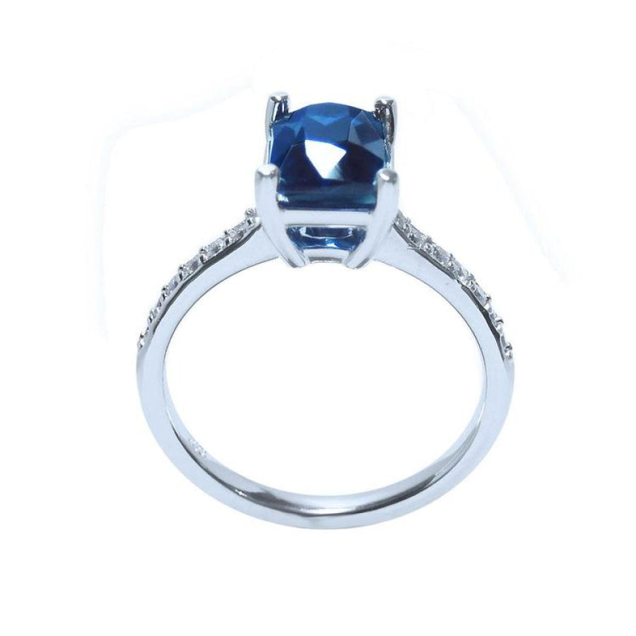 18K white gold ring with a radiant-cut deep blue sapphire and diamond accents.
