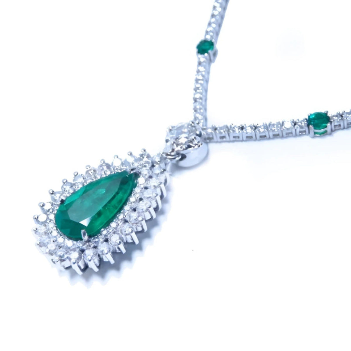 Pear cut emerald necklace with double diamond halo, 18K white gold chain with emerald accents.
