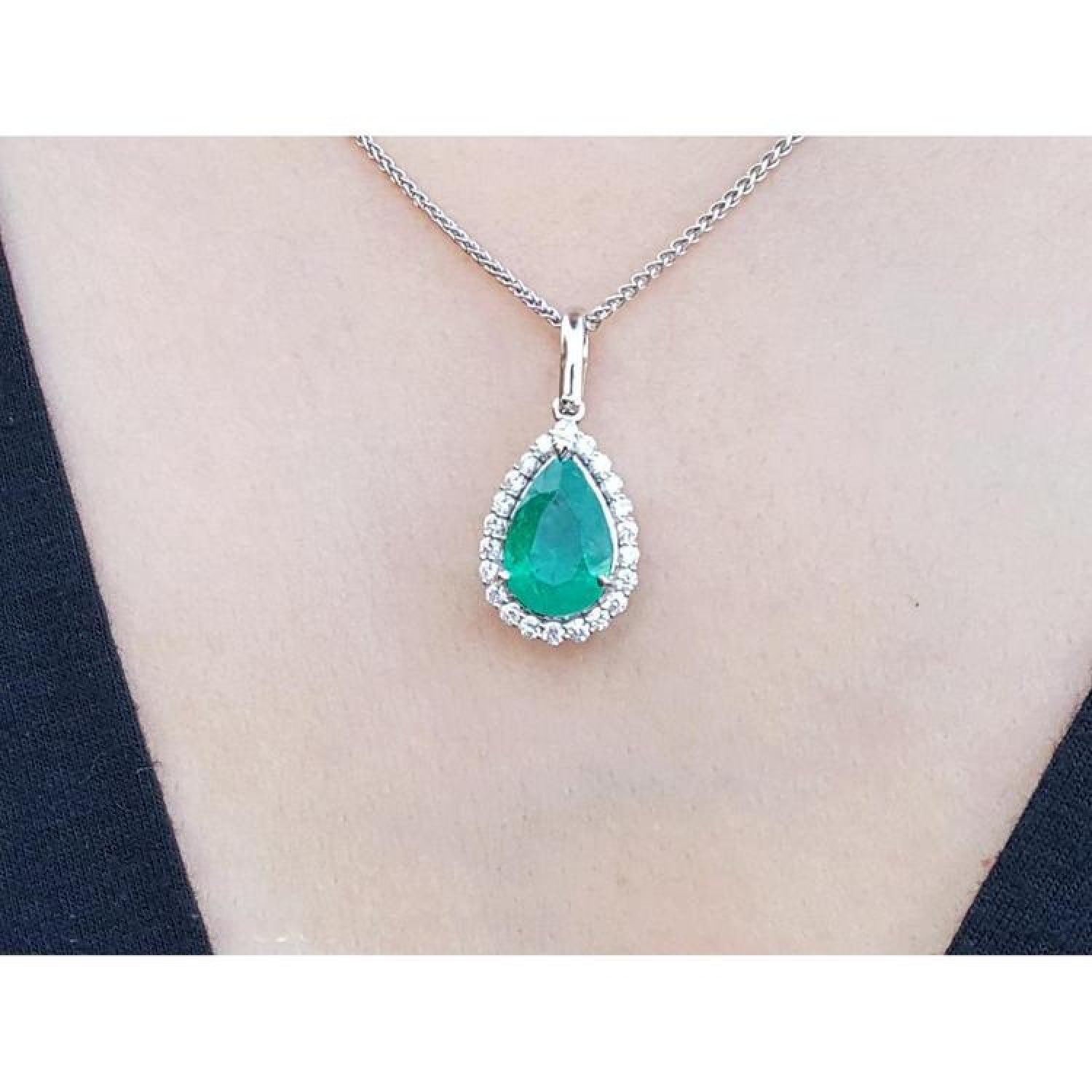 18K white gold pear-shaped emerald pendant with a halo of natural diamonds on a chain.