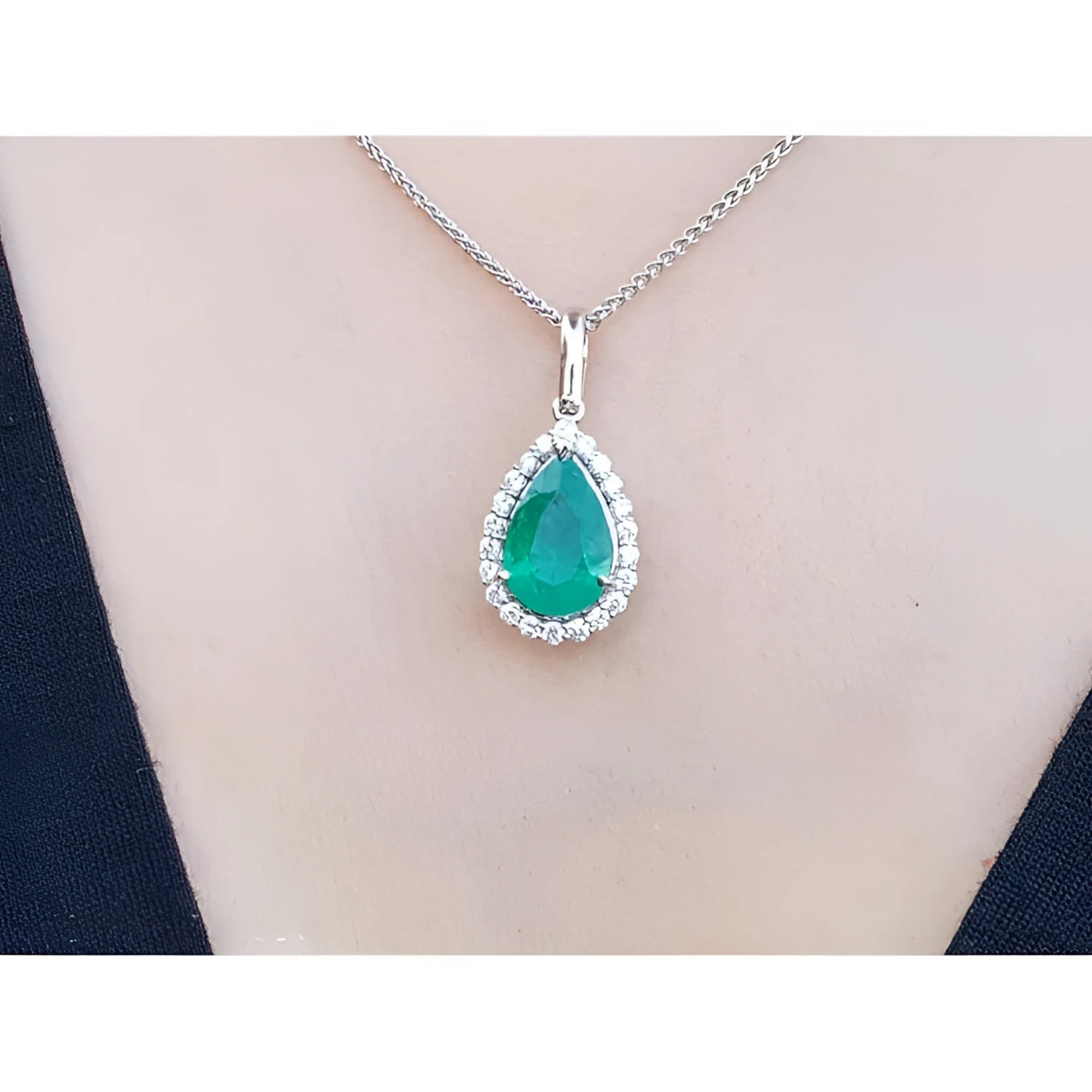 18K white gold pear-shaped emerald pendant with a halo of natural diamonds on a chain.