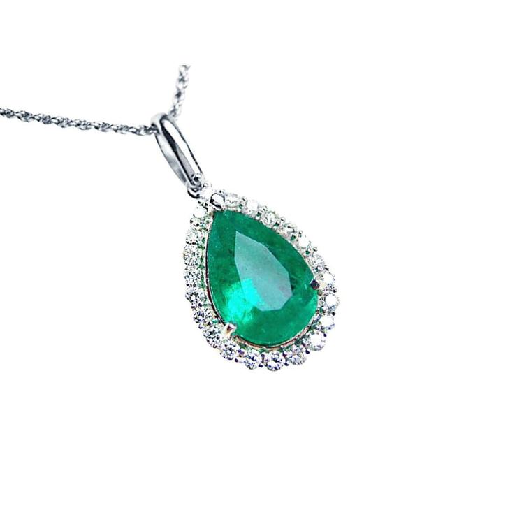 Emerald green teardrop pendant with diamond accents on a right-side position displaying topside view
