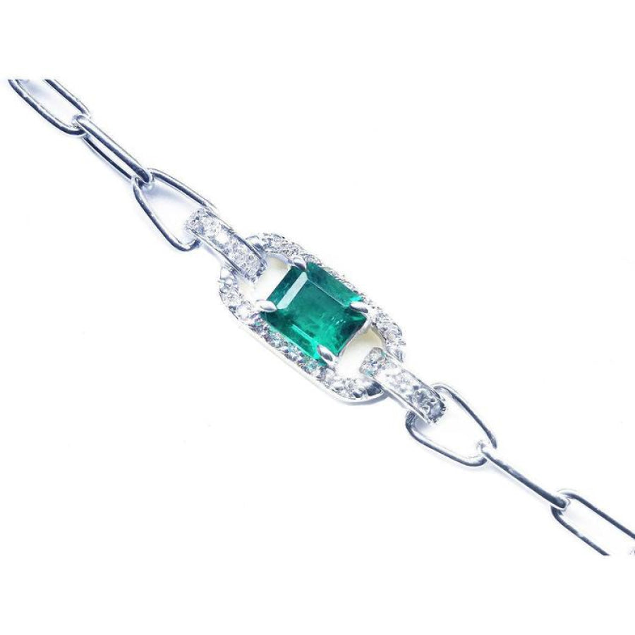 A 14k white gold paperclip bracelet with a natural colombian emerald and diamonds.