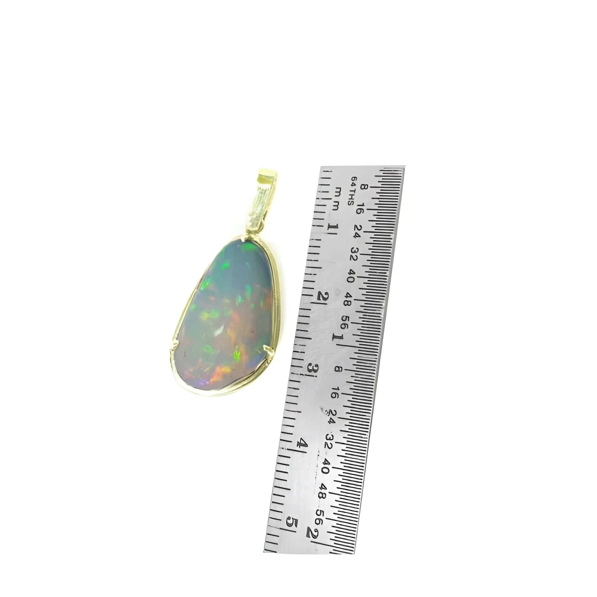 Natural Ethiopian opal pendant with rainbow flashes, set in 14K yellow gold, next to a ruler.