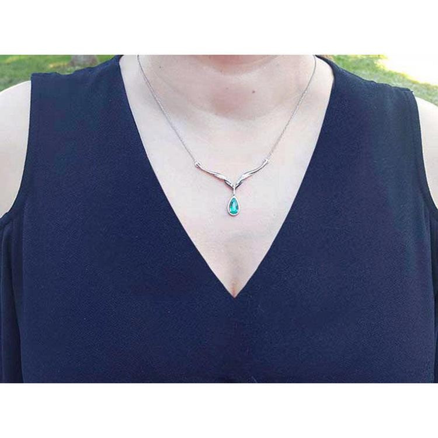 1.28 carat pear cut emerald necklace in 14K white gold with diamond accents and chevron design.