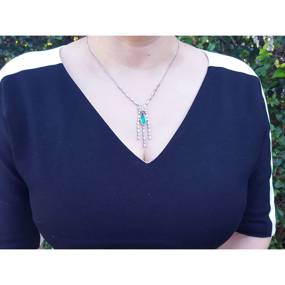 Woman wearing a marquise necklace 2.12 carats Colombian emerald and diamonds 14K white gold