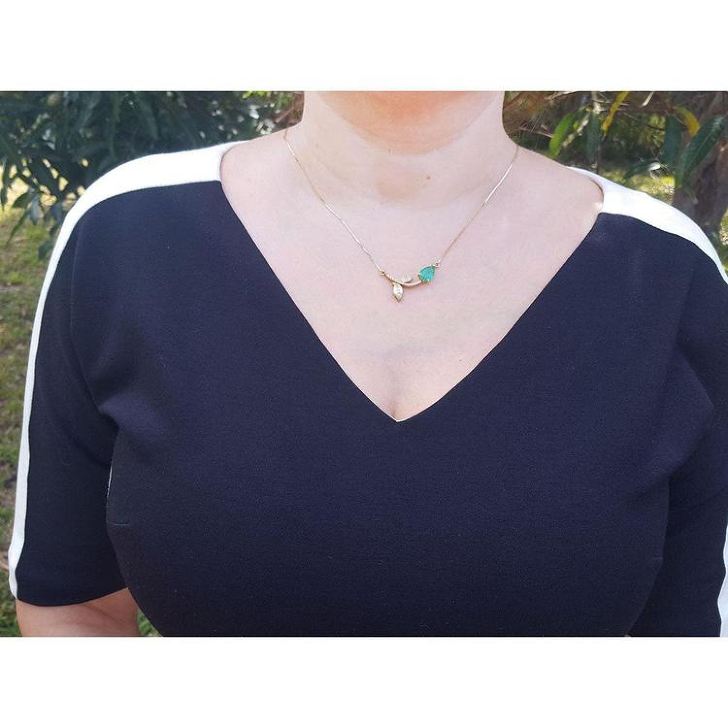 1.66 carat pear-cut natural emerald necklace in 14K yellow gold with a twig design.